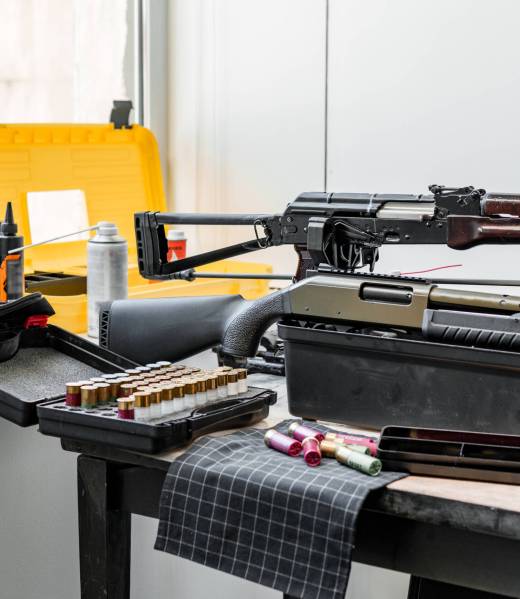 Shotgun rifle with cartridges on table in a weapon workshop close up